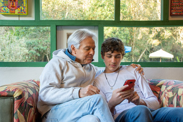 Father and teenage son with mobile phone fun social network
