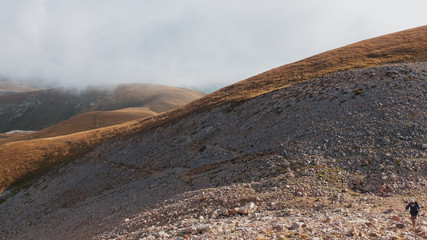 A route through mountain peaks and hills through majestic landscapes with tourists and travelers in the distance. Active tourists, hiking, Caucasus Mountains Oshten Fisht.