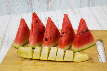 Close - up of a few slices of refreshing watermelon with slices of melon on a wooden Board. Raw organic fruits vegetables. Useful product.