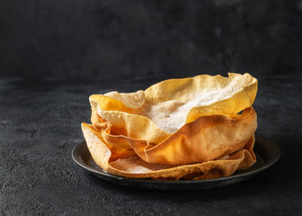 Close up Papadum or papad traditional indian food, vegetarian bread from lentils or beans. Food popular in Nepalese, Pakistani, Indian and Bangladeshi cuisines. Space for text, dark background.