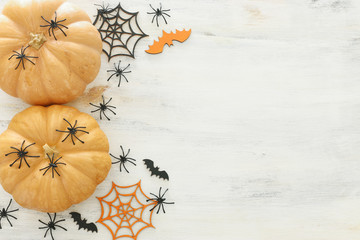 holidays Halloween image. pumpkin, bats and spiders over wooden white table. top view, flat lay