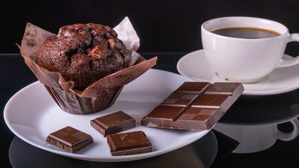 Chocolate muffin, Chocolate and cup of black coffee on the table.