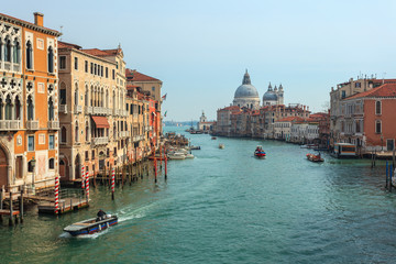View of Canal Grande. Various boats float by a fine architectural complex of embankments.