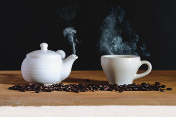 White Hot coffee cup with white pot and roasters bean on table.