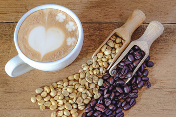 Raw coffee bean and roasters coffee bean in wood spoon and hot late art coffee on table.