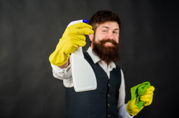 Male janitor with cleaning equipments. Domestic service cleaner man with rag and cleaner spray. Bearded man in uniform, rubber gloves with cleaning products. Professional cleaning man in uniform.