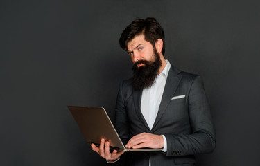 Work at office. Serious man with laptop computer. Businessman works with notebook in office. Businessman with computer at workplace. Businessman works with laptop. Technology, networking and internet.