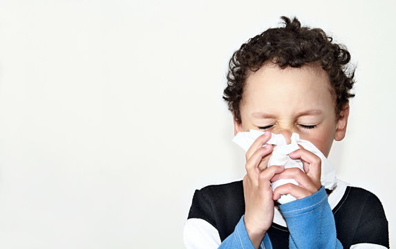 child blowing nose after catching a cold with white background stock photo