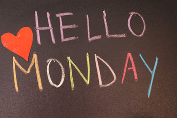 handwriting hello monday on chalkboard with colorful chalk and heart paper