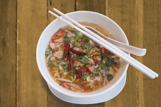 Hot and spicy tomyam nooddle in white bowl.