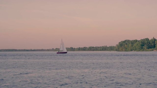 Yacht is sailing on the river at beautiful sunset