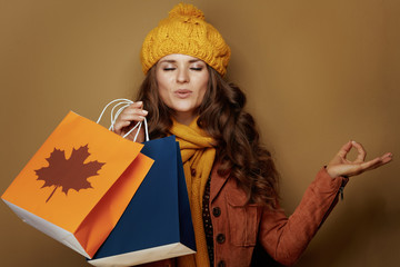 relaxed young woman with autumn shopping bags meditating