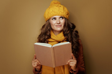 woman with book looking at copy space on brown background