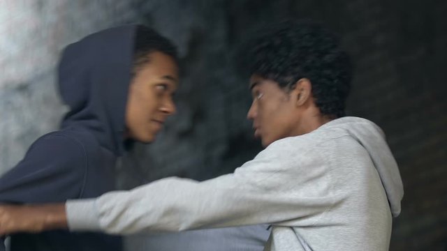 African-American male teenagers quarrelling and pushing each other, hooligans