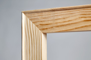 Corner of a wooden stretcher bar for canvas on grey background