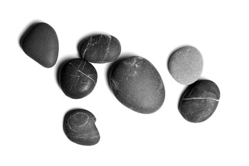 Obraz na płótnie Canvas Scattered sea pebbles. Smooth gray and black spa stones isolated on white background. Top view