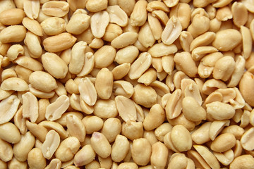 roasted peeled peanuts, salted snack as background. high calorie product