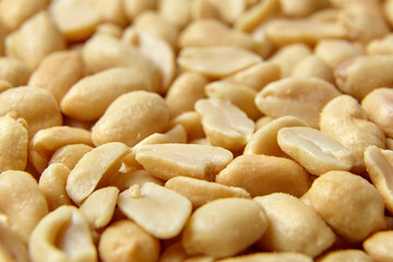 roasted peeled peanuts, salted snack as background. high calorie product
