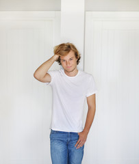 Teenager standing near white wall