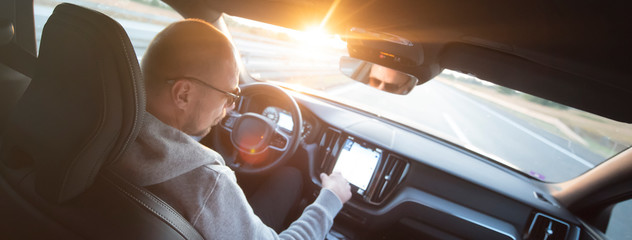 Man driving car with mobile navigation system. Male using navigation system with map gps navigation...