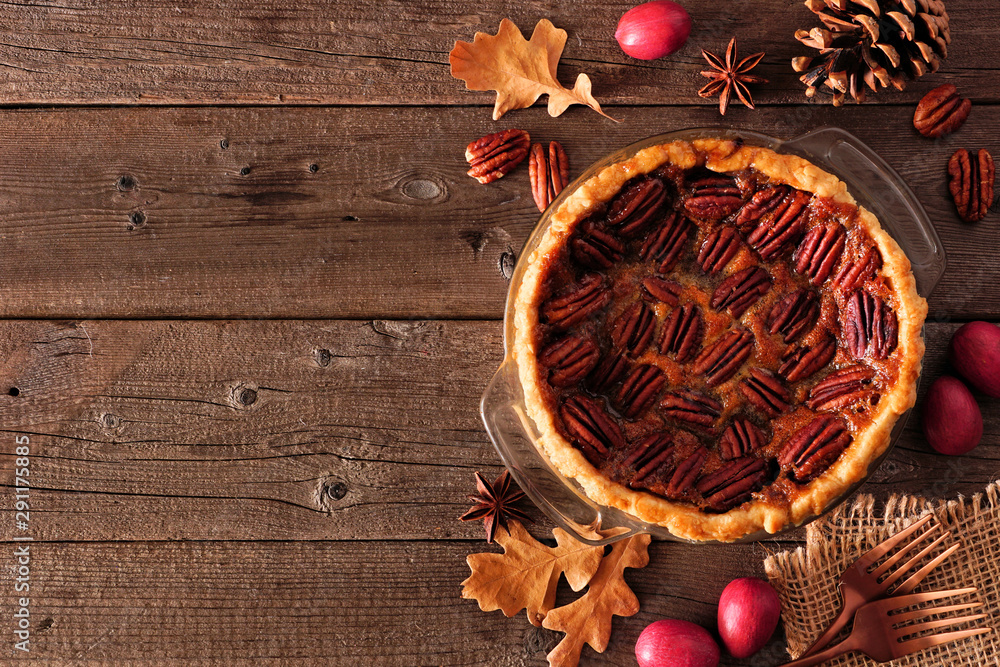 Poster homemade autumn pecan pie side border. top view table scene over a rustic wood background with copy 