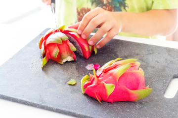 Boy cuts dragon fruit