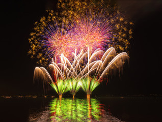 Spektakuläres Feuerwerk spiegelt sich im See