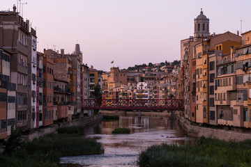 Colorful yellow and orange houses reflected in water river Onyar, in Girona, Catalonia, Spain.