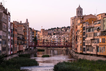 Colorful yellow and orange houses reflected in water river Onyar, in Girona, Catalonia, Spain.