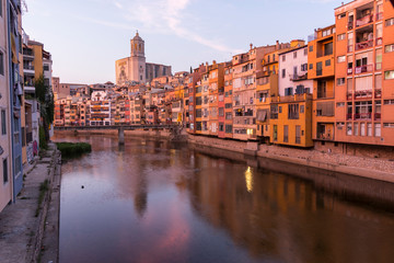 Colorful yellow and orange houses reflected in water river Onyar, in Girona, Catalonia, Spain.