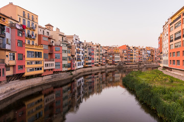 Fototapeta na wymiar Colorful yellow and orange houses reflected in water river Onyar, in Girona, Catalonia, Spain.