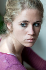 Young blonde girl photographed in the cloister of an old building