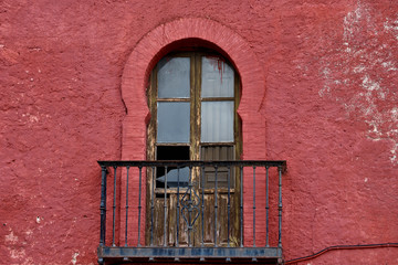 Obraz premium balcony with arabic arch in the red wall of the castle