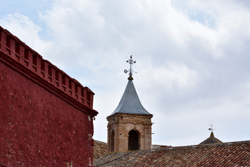 hire cultures between the red arabic wall and the tower of a christian church