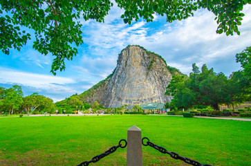 Pattaya, Thailand - July 2019 :Tourist travelling and taking photo with beautiful Buddha Mountain (Khao Chee chan) during cloudy day. Khao chee chan the largest buddha carved in the world..