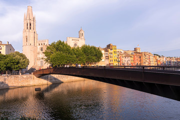 Colorful yellow and orange houses reflected in water river Onyar, in Girona, Catalonia, Spain.