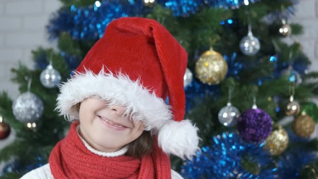 Playful Christmas. Cheerful little girl wearing a santa claus hat.