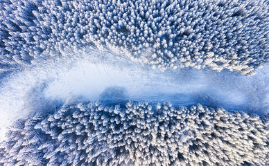 Aerial view on the road and forest at the winter time. Natural winter landscape from air. Forest under snow a the winter time. Winter - image