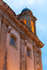 Old street in Marsala at night in rain with reflection of street lights on water, Sicily, Italy