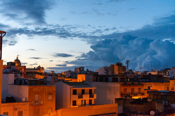 Cityscape, old Marsala city at night in rain with street lights and clouds, Sicily, Italy