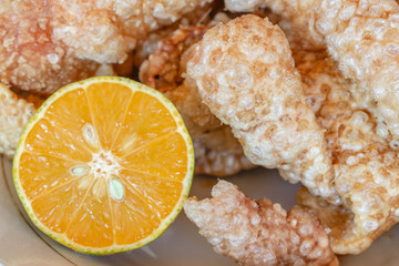 Skin of pork fried in large strips accompanied with lemon clove cut in half. Pork Rind. Brazilian snack known as 