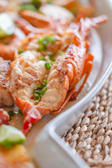 Grilled seafood with lobster, shrimp, squid and fish, accompanied by various vegetables.