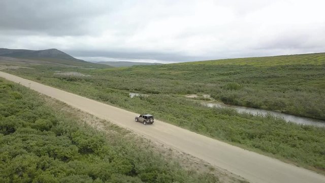 Aerial view of a jeep driving on a dirt road in Nome, Alaska.
