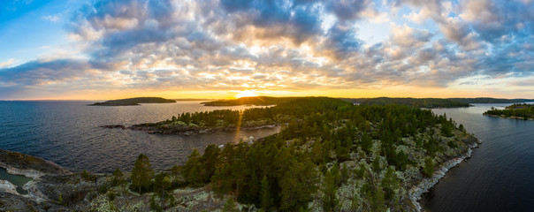 Panorama of Karelia at sunrise. Islands in lake Ladoga. Top view of the sunrise over the lake. Skerries in lake Ladoga. Northern nature. Trip to Russia. Natural attractions of Russia.