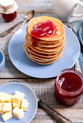 Tasty breakfast. Pancakes with strawberry confiture and butter.