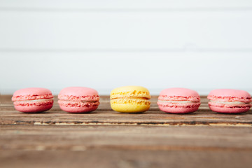 Sweet colorful French macaroon cookies dessert on brown wooden table over white wooden background