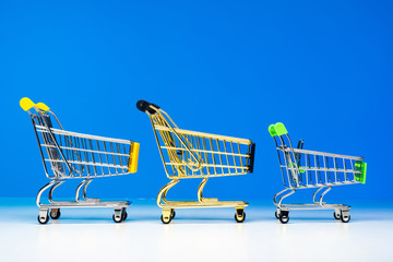 Shopping carts on wheels are behind each other. The store has everything you need. Purchases. Sale of goods. Queues in stores. Electronic queue for service. Few purchases due to high prices.