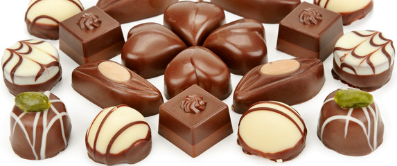 Chocolate candies isolated on white background. Flat lay, top view.Wide photo.