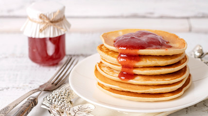 Tasty breakfast. Pancakes with strawberry confiture and butter.