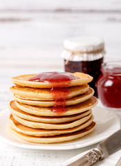 Tasty breakfast. Pancakes with strawberry confiture and butter.